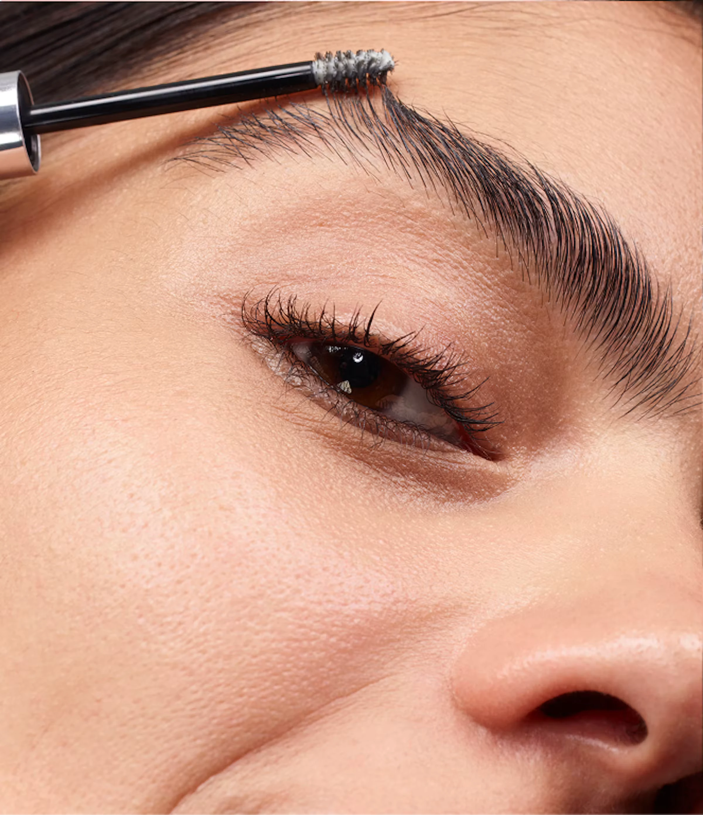 Close-up of a brow being brushed with a Boy Brow wand