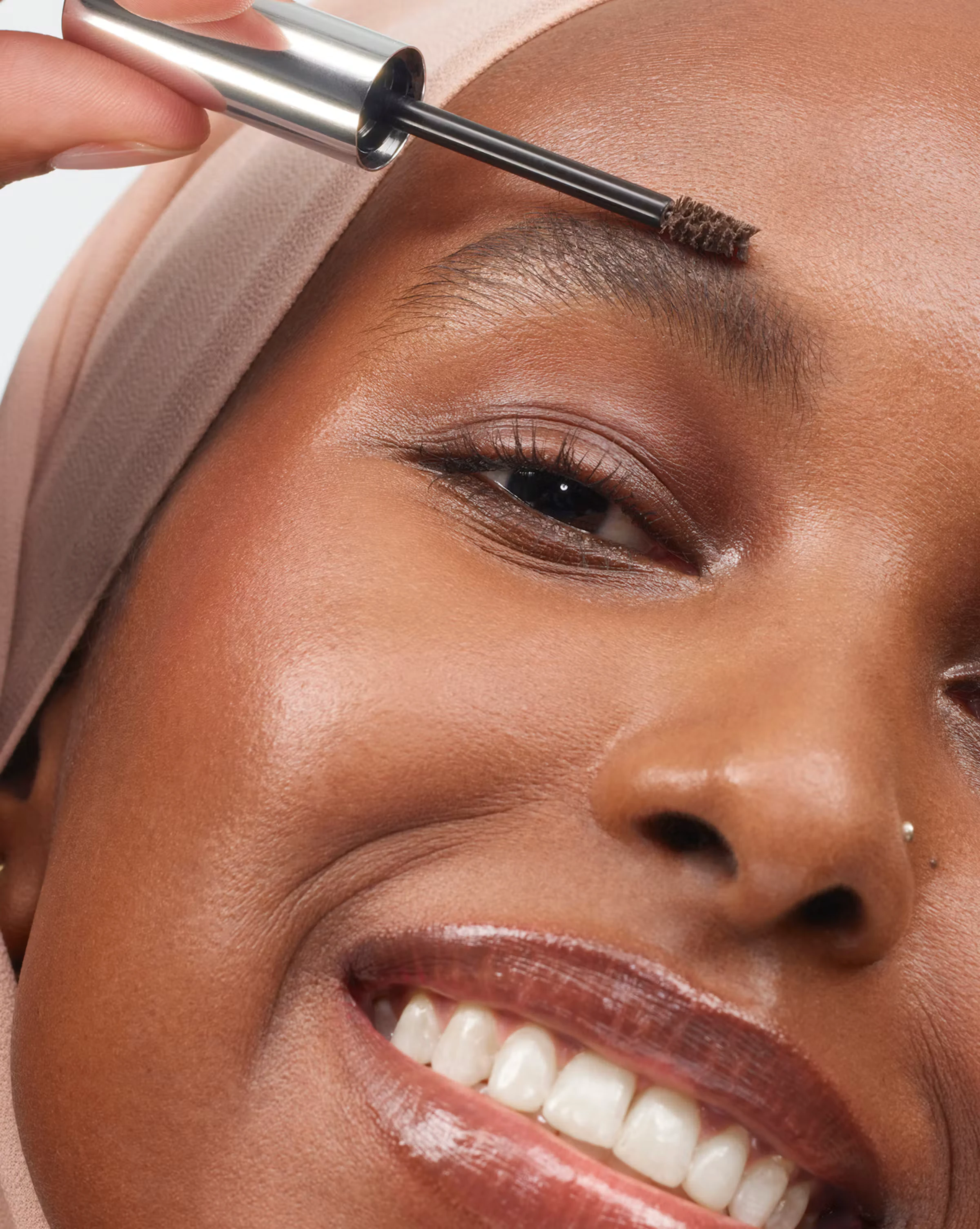 Smiling person with a headwrap and defined brows, Boy Brow carousel photo