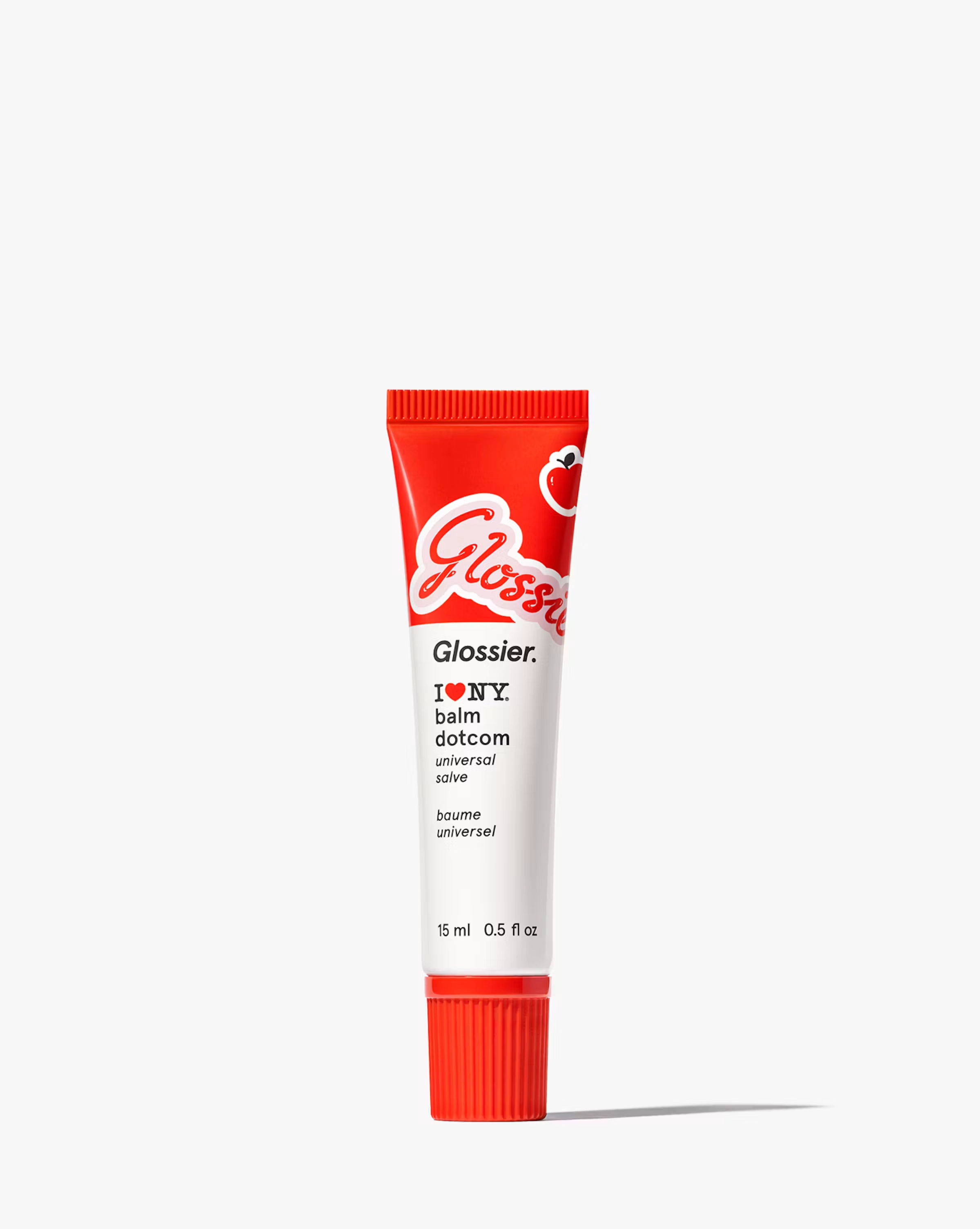 A red Glossier lip tube standing on a pale background