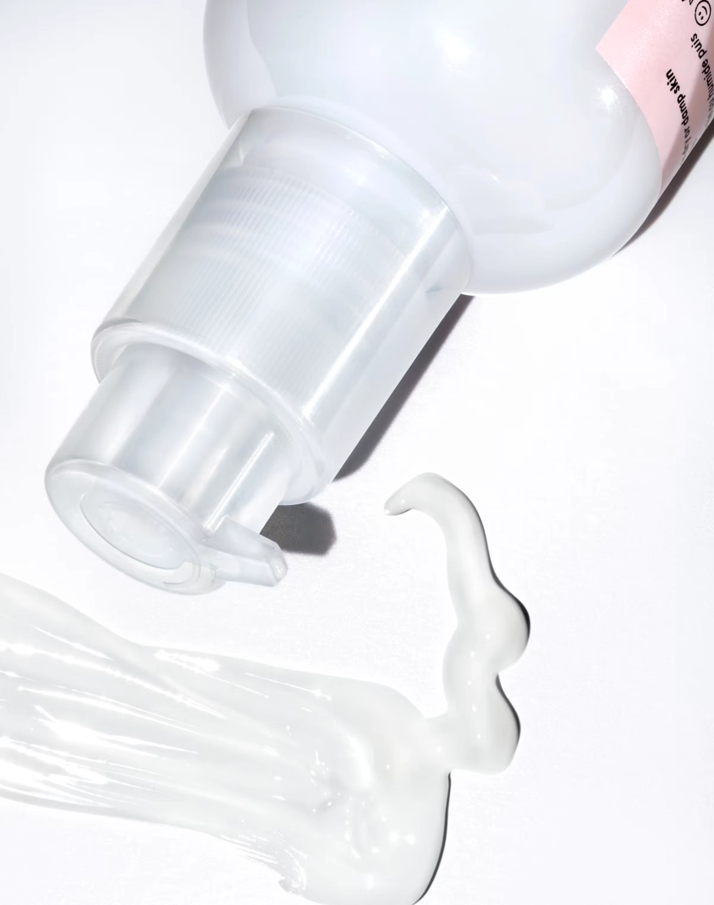 A pump bottle with a ribbon of clear gel running across white